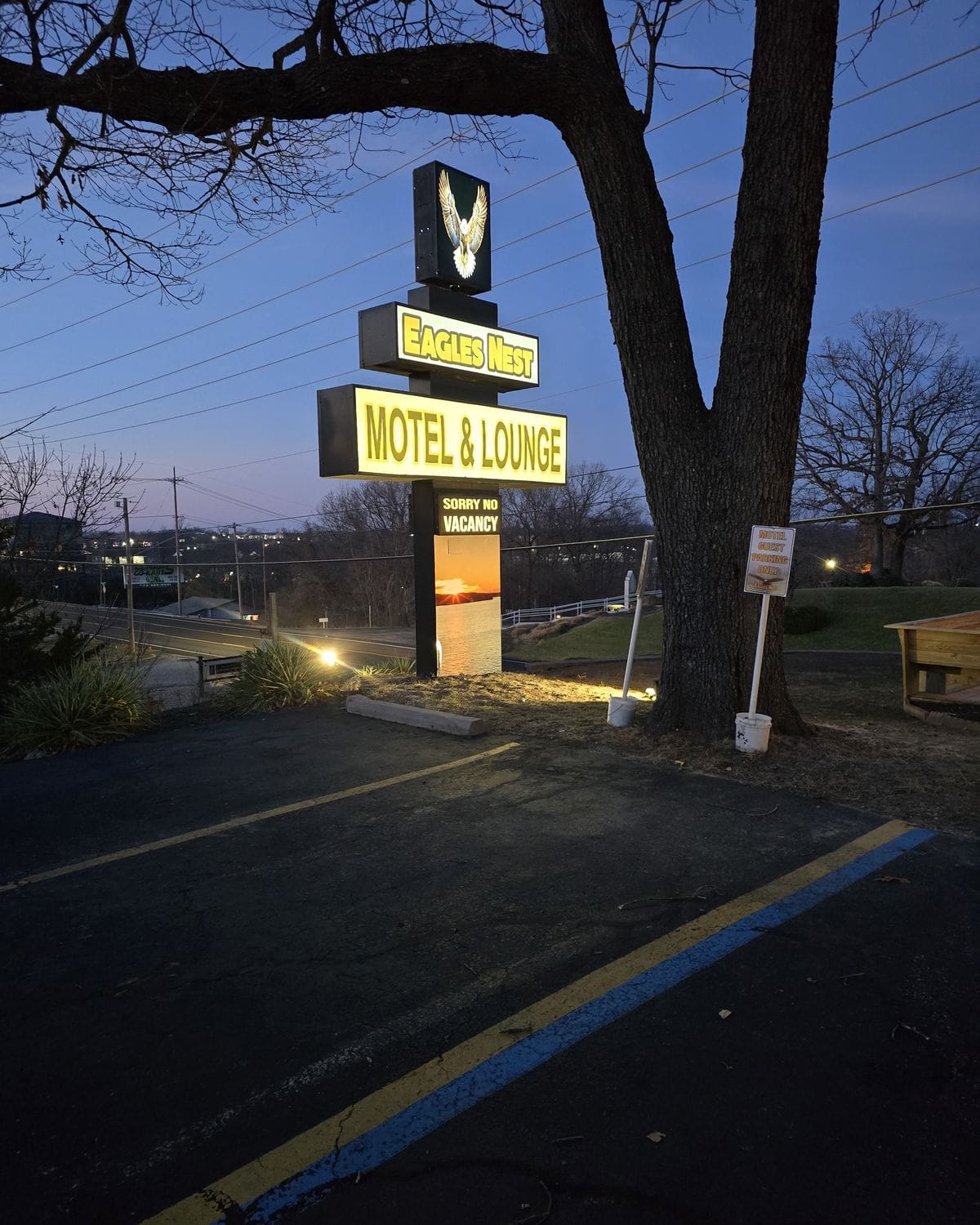 Lit Eagles Nest Motel & Lounge sign on the Bagnell Dam Strip at dusk